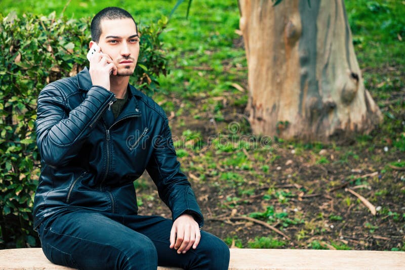 Gelukkige jonge mens met smartphone Het spreken op de telefoon royalty-vrije stock afbeelding Gelukkige jonge mens met smartphone Het spreken op de telefoon royalty-vrije stock afbeelding