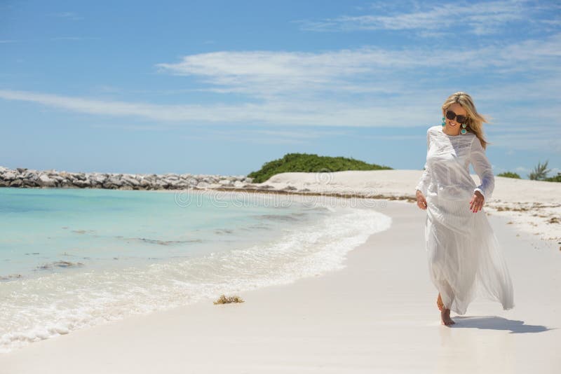Gelukkige jonge vrouw die op het strand lopen stock afbeeldingen Gelukkige jonge vrouw die op het strand lopen stock afbeeldingen