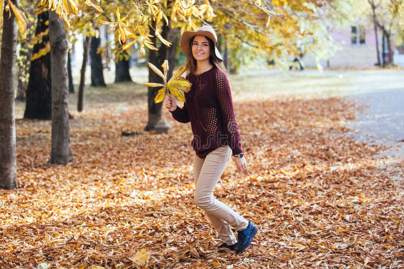 Gelukkige jonge vrouw die prettijd in de herfst hebben in openlucht Vrolijk glimlachend meisje die in de herfst in werking stelle royalty-vrije stock foto Gelukkige jonge vrouw die prettijd in de herfst hebben in openlucht Vrolijk glimlachend meisje die in de herfst in werking stelle royalty-vrije stock foto