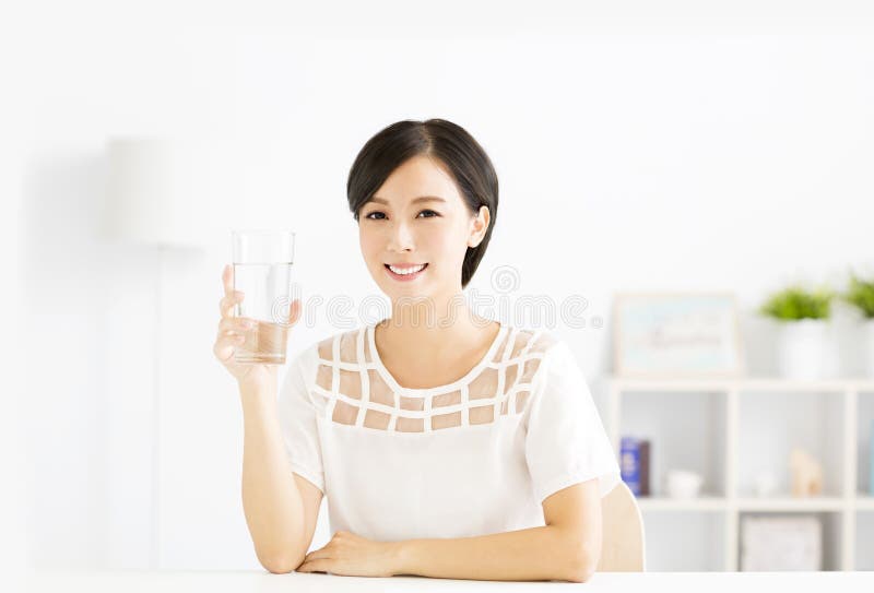 Gelukkige jonge vrouw die zoet water drinken stock foto Gelukkige jonge vrouw die zoet water drinken stock foto