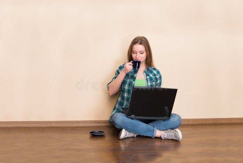 Gelukkige jonge vrouwenzitting op de vloer met gekruiste benen, het gebruiken stock afbeeldingen Gelukkige jonge vrouwenzitting op de vloer met gekruiste benen, het gebruiken stock afbeeldingen