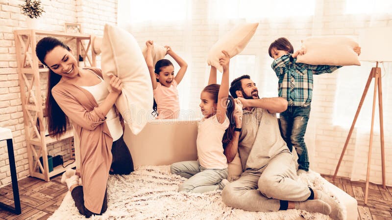 Gelukkige Kinderen met Ouders die Hoofdkussenstrijd hebben royalty-vrije stock foto's Gelukkige Kinderen met Ouders die Hoofdkussenstrijd hebben royalty-vrije stock foto's