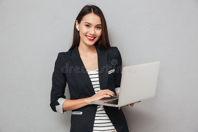 Gelukkige laptop van de bedrijfsvrouwenholding computer en het bekijken camera stock foto Gelukkige laptop van de bedrijfsvrouwenholding computer en het bekijken camera stock foto