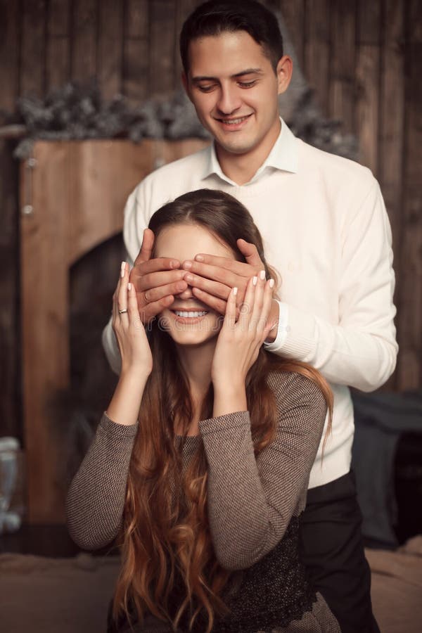 Gelukkige Man die de ogen van de vrouw behandelen met zijn handen Verrast meisje i stock foto's Gelukkige Man die de ogen van de vrouw behandelen met zijn handen Verrast meisje i stock foto's