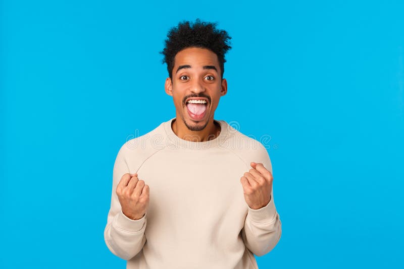 Happy guy got huge chance, winning lottery, got employed awesome company. Attractive african-american male celebrting excellent news, triumphing, shaking fists and smiling joyfully, blue background. Happy guy got huge chance, winning lottery, got employed awesome company. Attractive african-american male celebrting excellent news, triumphing, shaking fists and smiling joyfully, blue background.