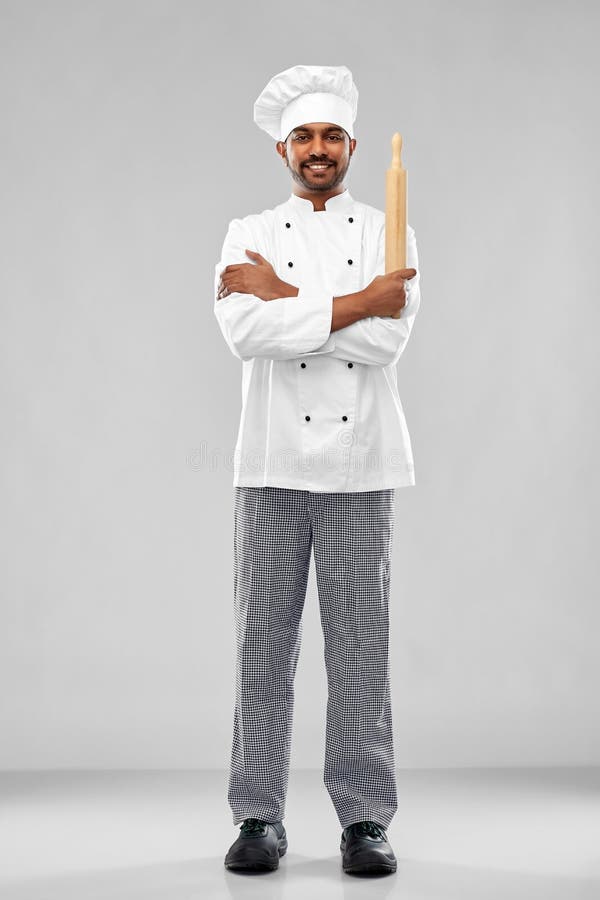 Gelukkige mannelijke Indische chef-kok of bakker met deegrol stock foto Gelukkige mannelijke Indische chef-kok of bakker met deegrol stock foto