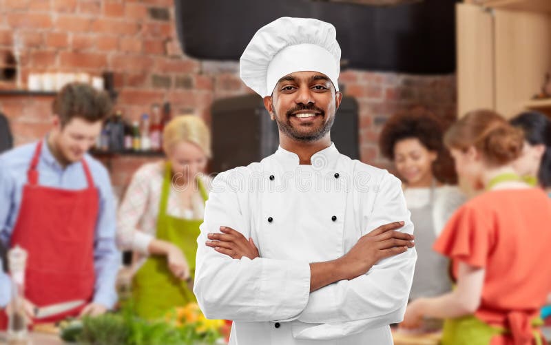 Gelukkige mannelijke Indische chef-kok in toque bij het koken van klasse stock foto Gelukkige mannelijke Indische chef-kok in toque bij het koken van klasse stock foto