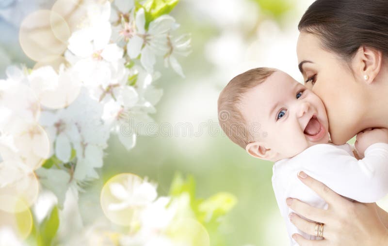 Gelukkige moeder die aanbiddelijke baby kussen stock afbeeldingen Gelukkige moeder die aanbiddelijke baby kussen stock afbeeldingen
