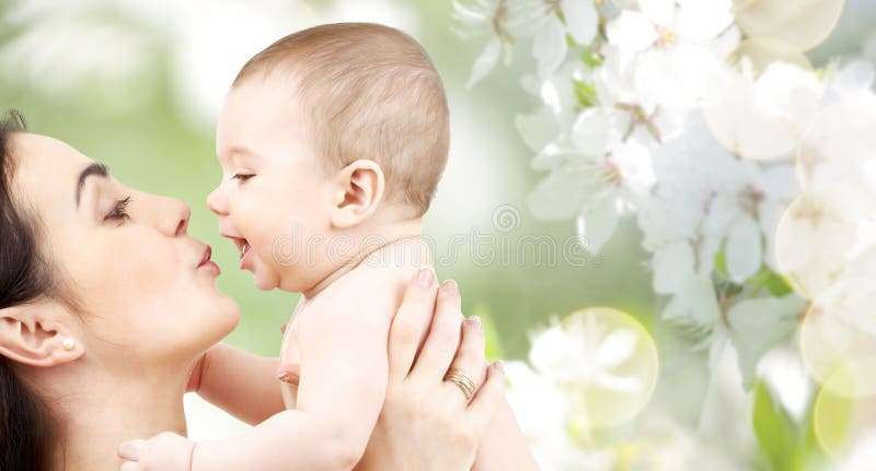 Gelukkige moeder die aanbiddelijke baby kussen stock fotografie Gelukkige moeder die aanbiddelijke baby kussen stock fotografie