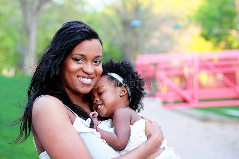 Portrait of happy beautiful African American women with her cute toddler girl. Portrait of happy beautiful African American women with her cute toddler girl.