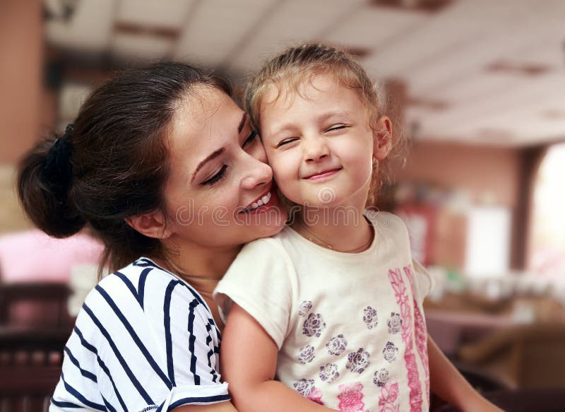 Gelukkige moeder en leuk het genieten van meisje geknuffel met liefde binnen stock foto Gelukkige moeder en leuk het genieten van meisje geknuffel met liefde binnen stock foto