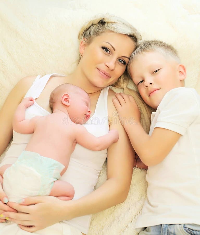 Gelukkige moeder met twee kinderen die samen op bedhuis slapen stock afbeeldingen Gelukkige moeder met twee kinderen die samen op bedhuis slapen stock afbeeldingen