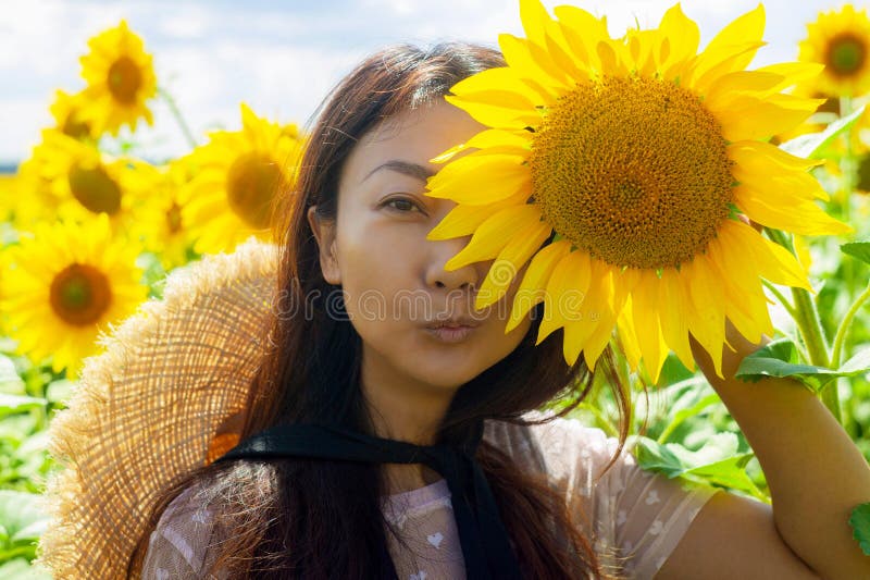 Gelukkige mooie Aziatische vrouw met strohoed op zonnebloemgebied royalty-vrije stock foto's Gelukkige mooie Aziatische vrouw met strohoed op zonnebloemgebied royalty-vrije stock foto's
