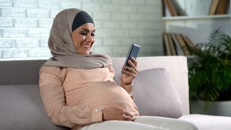 Gelukkige moslimvrouw die zwangerschapsonderzoek controleren online, gezondheidszorg, moederschap royalty-vrije stock afbeelding Gelukkige moslimvrouw die zwangerschapsonderzoek controleren online, gezondheidszorg, moederschap royalty-vrije stock afbeelding