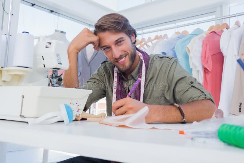 Gelukkige ontwerper die bij zijn bureau werken stock afbeeldingen Gelukkige ontwerper die bij zijn bureau werken stock afbeeldingen
