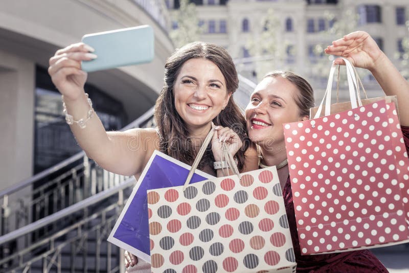 Gelukkige opgetogen vrouwen die hun het winkelen zakken tonen royalty-vrije stock fotografie Gelukkige opgetogen vrouwen die hun het winkelen zakken tonen royalty-vrije stock fotografie