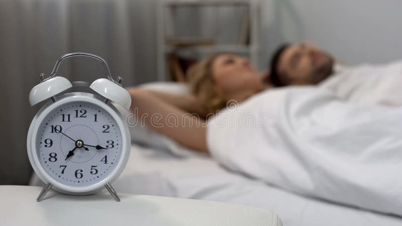 Gelukkige paarontwaken met wekker in ochtend, die in bed, gezinsleven liggen royalty-vrije stock foto Gelukkige paarontwaken met wekker in ochtend, die in bed, gezinsleven liggen royalty-vrije stock foto