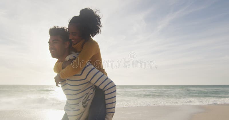 Gelukkige paniekman die een gynaecologische vrouw vervoert en plezier heeft op het strand