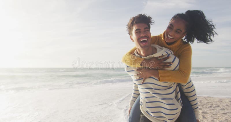 Gelukkige paniekman die een gynaecologische vrouw vervoert en plezier heeft op het strand