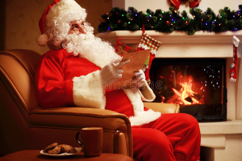 Gelukkige Santa Claus-zitting bij zijn ruimte thuis dichtbij Kerstboom en grote zak en lezingskerstmisbrief of wenslijst royalty-vrije stock afbeeldingen Gelukkige Santa Claus-zitting bij zijn ruimte thuis dichtbij Kerstboom en grote zak en lezingskerstmisbrief of wenslijst royalty-vrije stock afbeeldingen