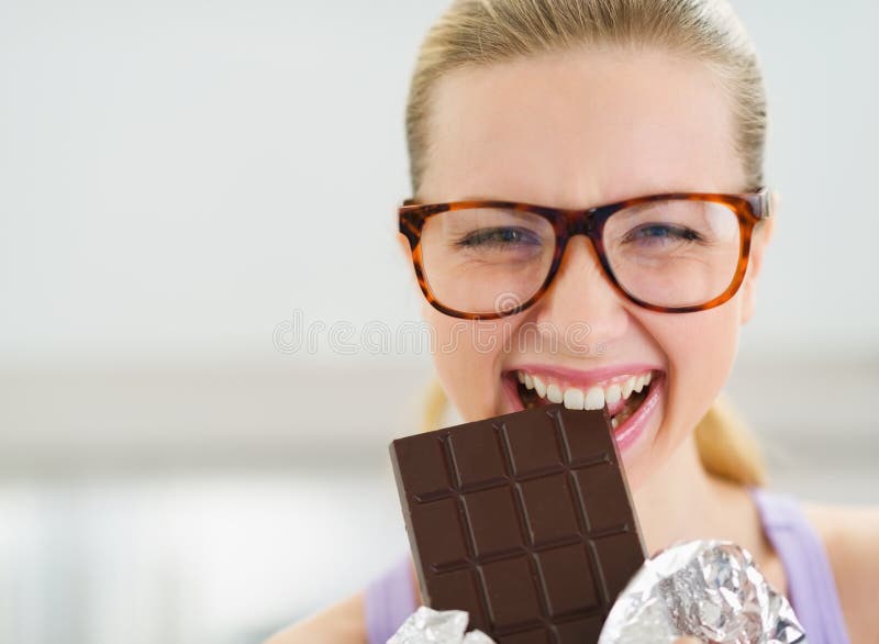 Gelukkige tiener die chocoladereep eten stock afbeeldingen Gelukkige tiener die chocoladereep eten stock afbeeldingen