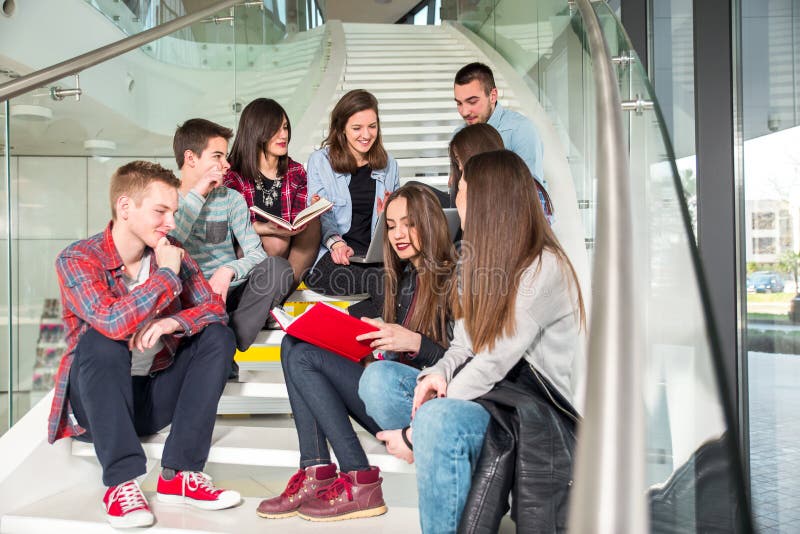 Happy teen girls and boys on the stairs school or college. Selective focus. Happy teen girls and boys on the stairs school or college. Selective focus