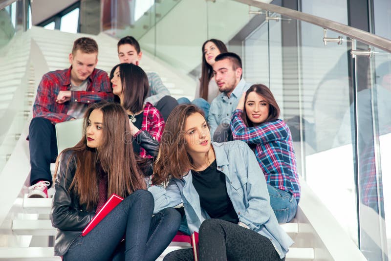 Happy teen girls and boys on the stairs school or college. Selective focus. Happy teen girls and boys on the stairs school or college. Selective focus