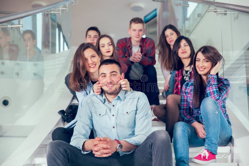 Happy teen girls and boys on the stairs school or college. Selective focus. Happy teen girls and boys on the stairs school or college. Selective focus