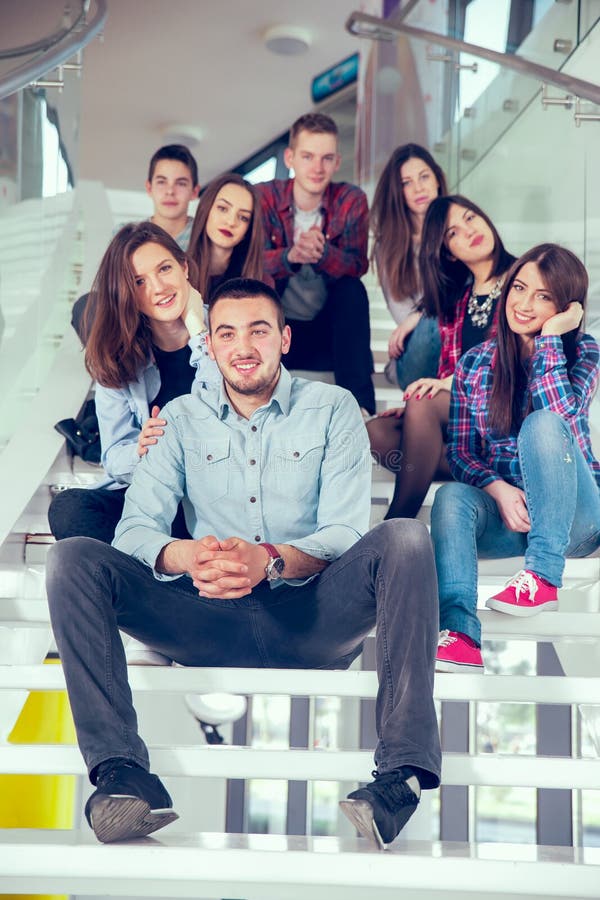 Happy teen girls and boys on the stairs school or college. Selective focus. Happy teen girls and boys on the stairs school or college. Selective focus