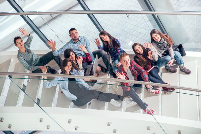 Happy teen girls and boys on the stairs school or college. Selective focus. Happy teen girls and boys on the stairs school or college. Selective focus