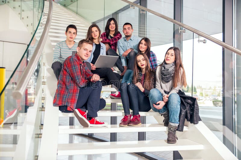 Happy teen girls and boys on the stairs school or college. Selective focus. Happy teen girls and boys on the stairs school or college. Selective focus