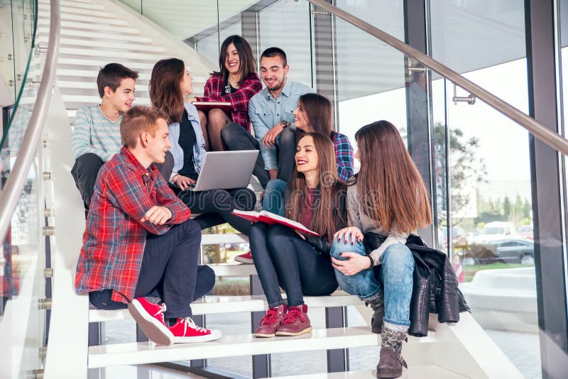 Happy teen girls and boys on the stairs school or college. Selective focus. Happy teen girls and boys on the stairs school or college. Selective focus