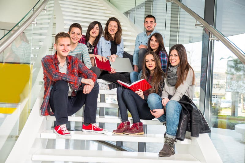 Happy teen girls and boys on the stairs school or college. Selective focus. Happy teen girls and boys on the stairs school or college. Selective focus