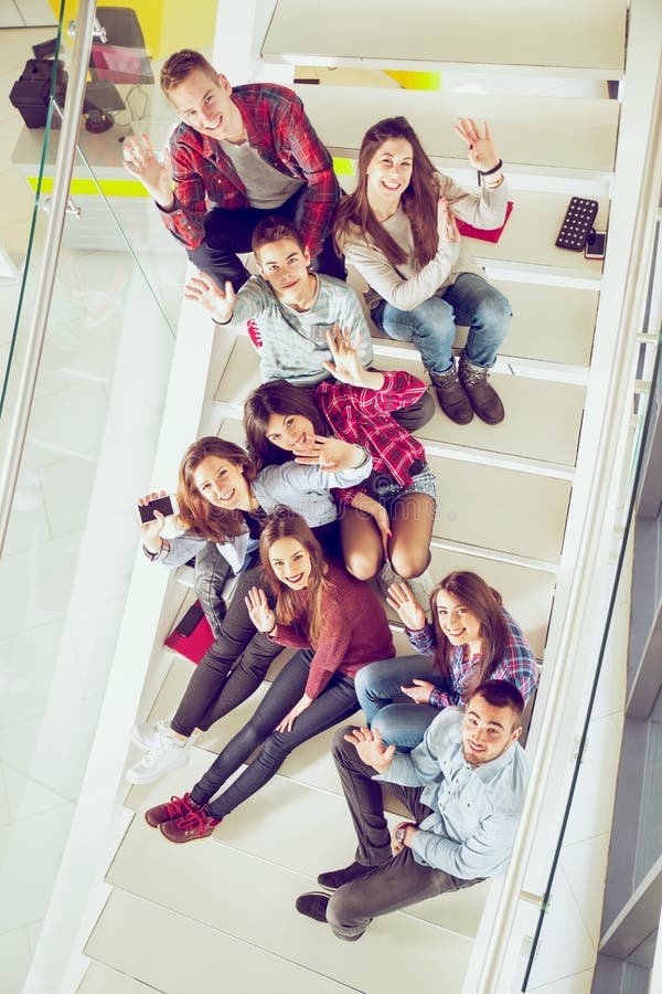 Happy teen girls and boys on the stairs school or college. Selective focus. Happy teen girls and boys on the stairs school or college. Selective focus