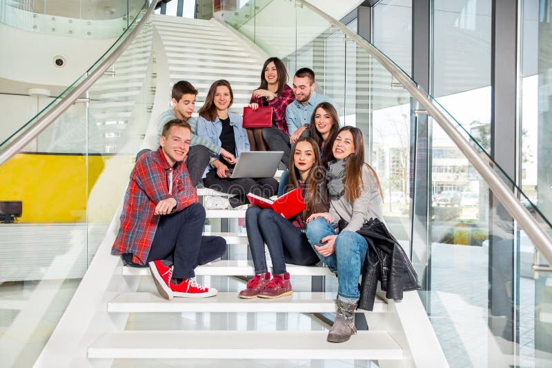 Happy teen girls and boys on the stairs school or college. Selective focus. Happy teen girls and boys on the stairs school or college. Selective focus