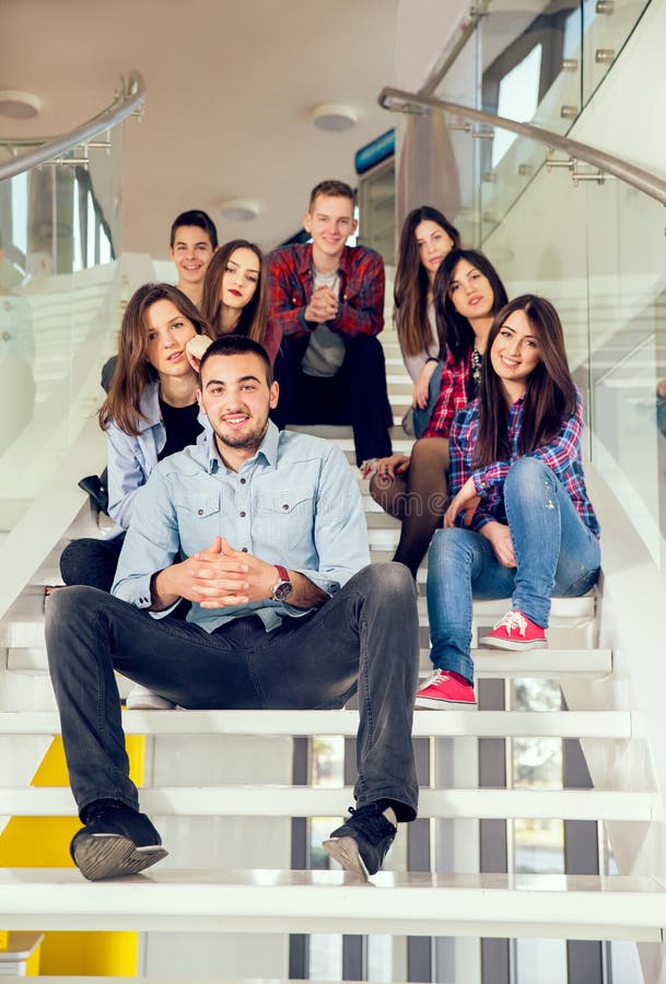 Happy teen girls and boys on the stairs school or college. Selective focus. Happy teen girls and boys on the stairs school or college. Selective focus