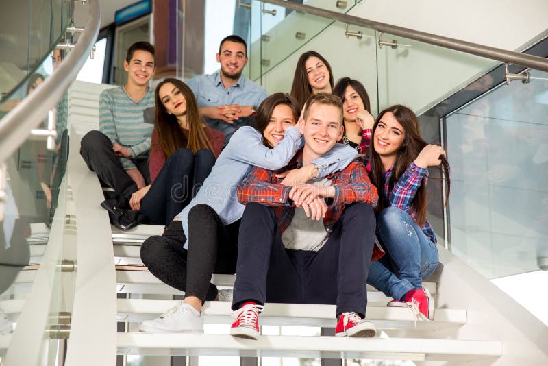 Happy teen girls and boys on the stairs school or college. Selective focus. Happy teen girls and boys on the stairs school or college. Selective focus