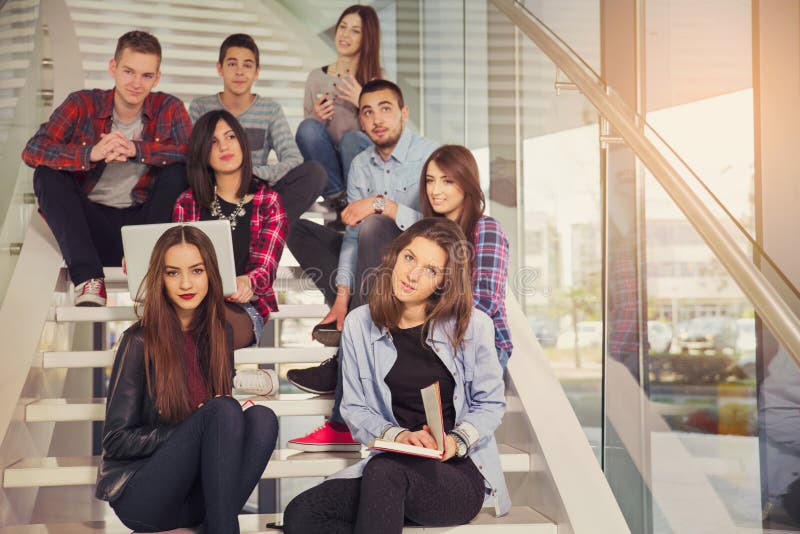 Happy teen girls and boys on the stairs school or college. Selective focus. Happy teen girls and boys on the stairs school or college. Selective focus