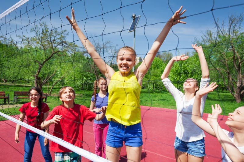 Gelukkige tieners die dichtbij het netto volleyball spelen stock afbeeldingen Gelukkige tieners die dichtbij het netto volleyball spelen stock afbeeldingen