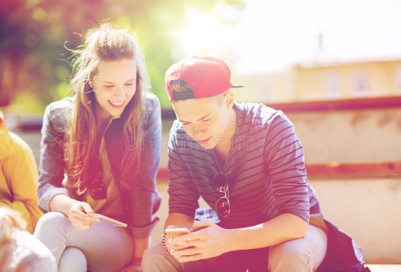 Gelukkige tienervrienden met smartphones in openlucht royalty-vrije stock foto's Gelukkige tienervrienden met smartphones in openlucht royalty-vrije stock foto's