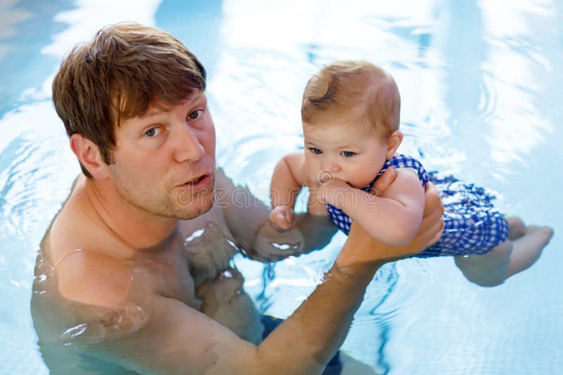 Gelukkige vader die op middelbare leeftijd met leuk aanbiddelijk babymeisje zwemmen in zwembad stock foto Gelukkige vader die op middelbare leeftijd met leuk aanbiddelijk babymeisje zwemmen in zwembad stock foto