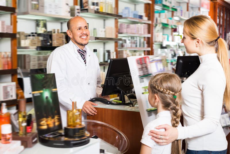 Gelukkige volwassen mannelijke apotheker die klanten helpen stock afbeeldingen Gelukkige volwassen mannelijke apotheker die klanten helpen stock afbeeldingen