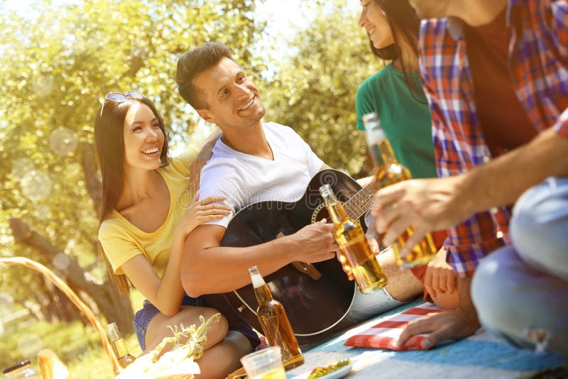 Gelukkige vrienden die picknick in park hebben royalty-vrije stock afbeeldingen Gelukkige vrienden die picknick in park hebben royalty-vrije stock afbeeldingen