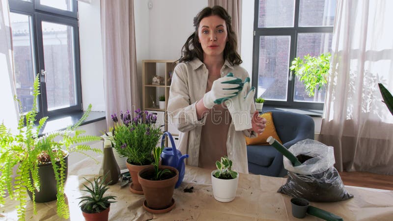 Gelukkige vrouw of blogger die thuis bloemen plant