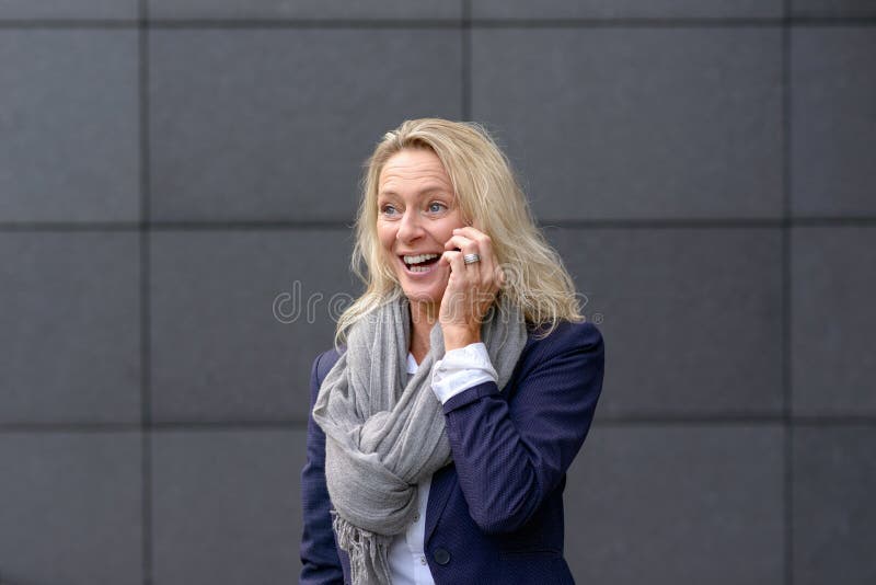 Gelukkige vrouw die en op mobiel haar lachen babbelen royalty-vrije stock foto's Gelukkige vrouw die en op mobiel haar lachen babbelen royalty-vrije stock foto's