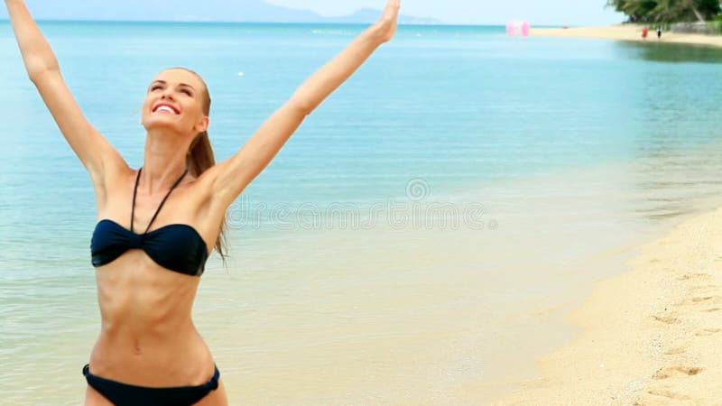 Gelukkige vrouw die op het strand lopen