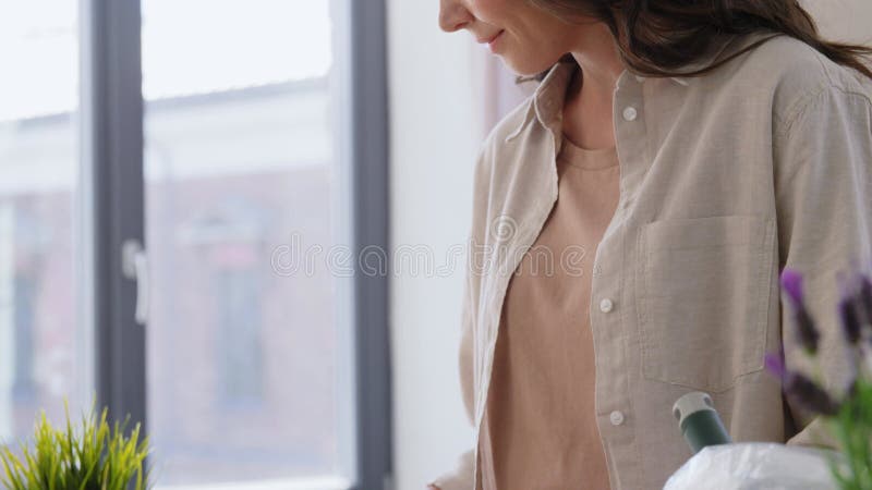 Gelukkige vrouw die thuis bloemen plant