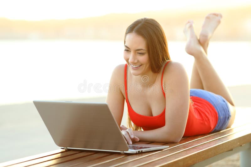 Gelukkige vrouw het doorbladeren media op laptop op het strand royalty-vrije stock afbeelding Gelukkige vrouw het doorbladeren media op laptop op het strand royalty-vrije stock afbeelding