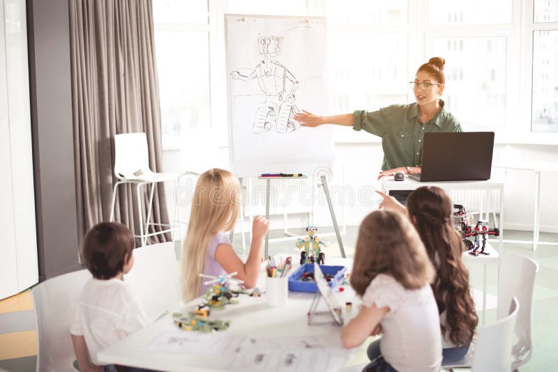 Gelukkige vrouw het vertellen jonge geitjes hoe makend stuk speelgoed royalty-vrije stock afbeelding Gelukkige vrouw het vertellen jonge geitjes hoe makend stuk speelgoed royalty-vrije stock afbeelding