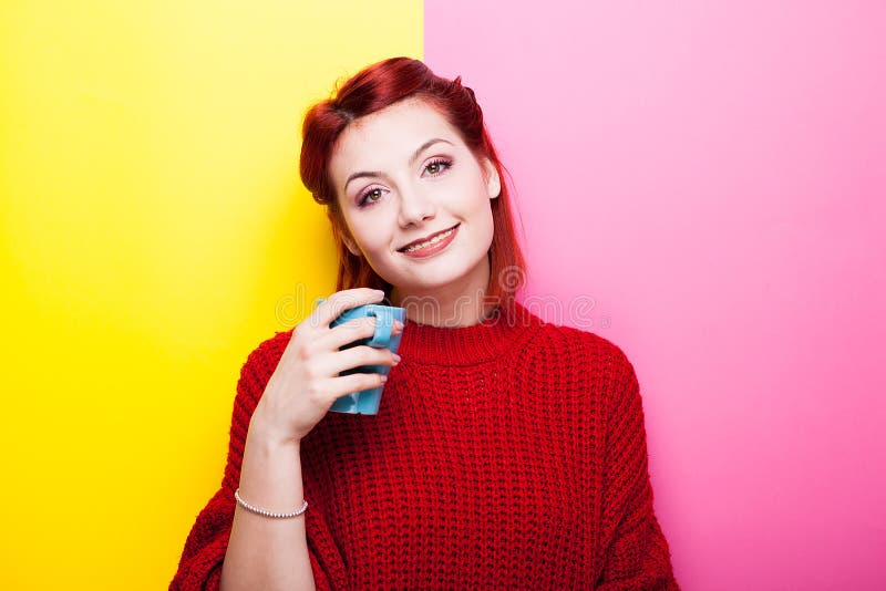 Gelukkige vrouw met een kop thee in handen die de camera bekijken stock fotografie Gelukkige vrouw met een kop thee in handen die de camera bekijken stock fotografie